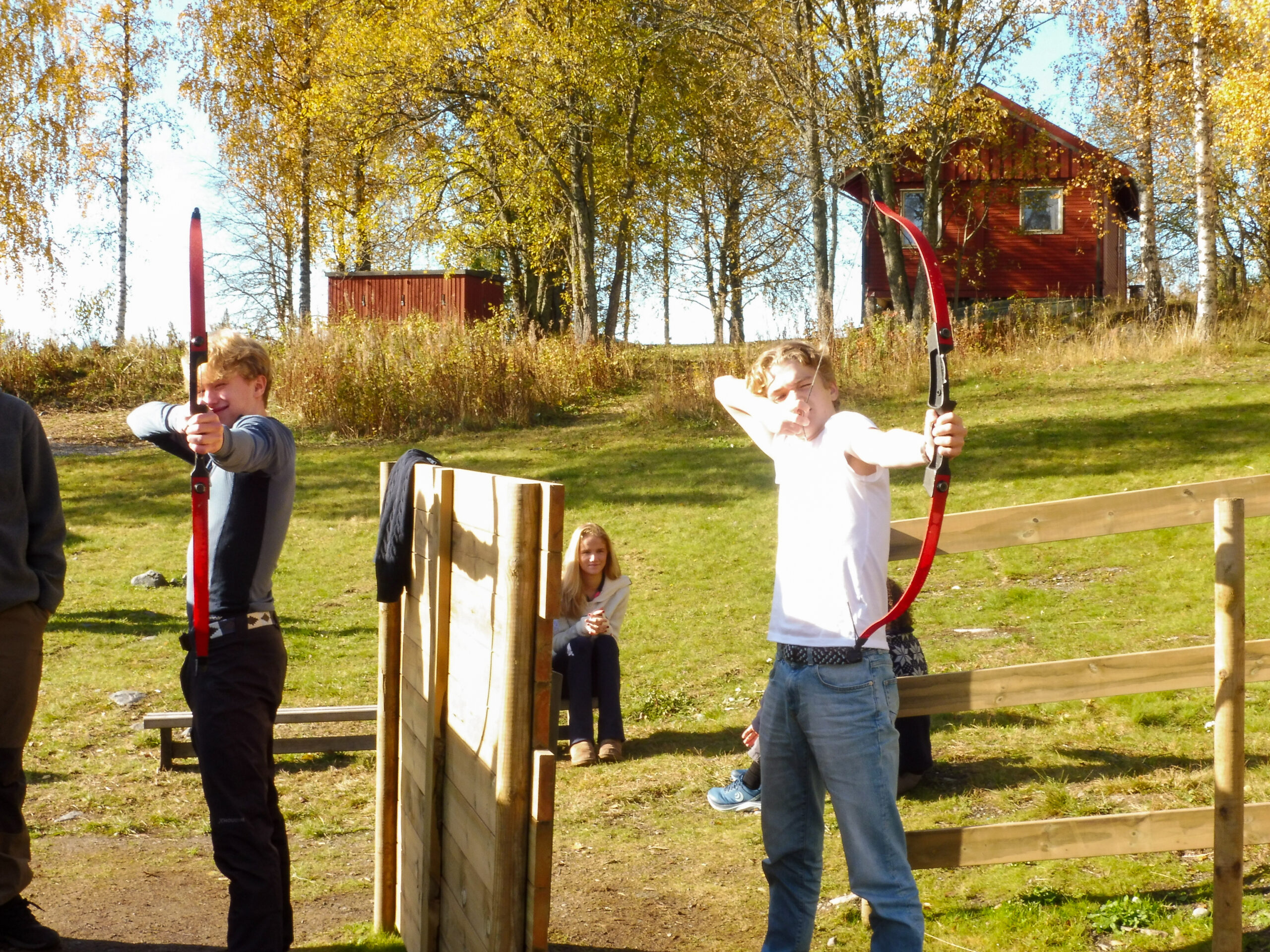 To elever sikter med pil og bue på en bueskytterbane